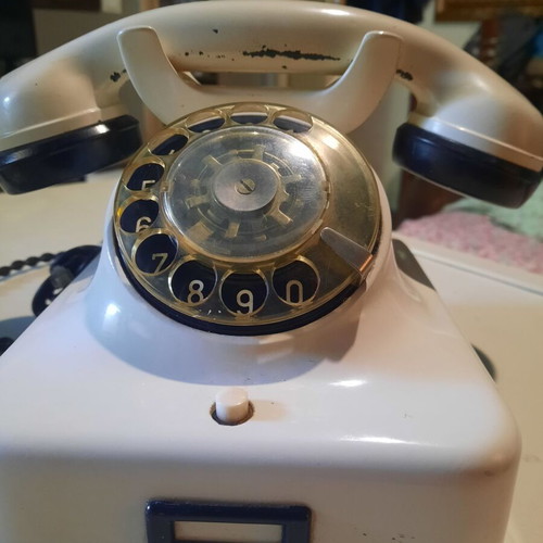 Old white bakelite telephone used, functional with cables