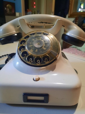 Old white bakelite telephone used, functional with cables
