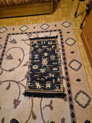 Small black rug with pixel designs like new, with fringes
