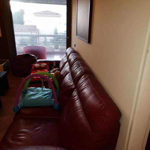 Entos four-seater leather sofa with footrest, like new, cherry color