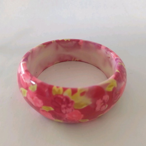 Bracelet asymmetric with pink flowers and green leaves on red background