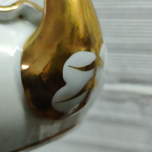 Antique porcelain teapot with wooden handle used