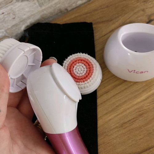 Facial cleansing device used with two heads and stand