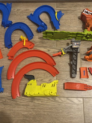 Hot Wheels track set pieces with T-Rex figure and launcher