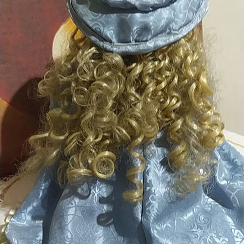 Porcelain Victorian-style doll with curly blonde hair and blue lace dress