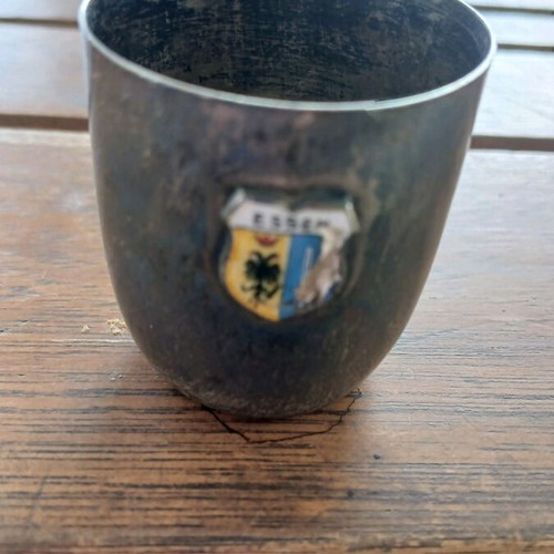 Silver shot glass used, with missing part on emblem