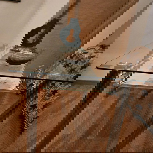 Γυάλινη τραπεζαρία σαν καινούργια με μεταλλικά πόδια και διακοσμητικό ράφι