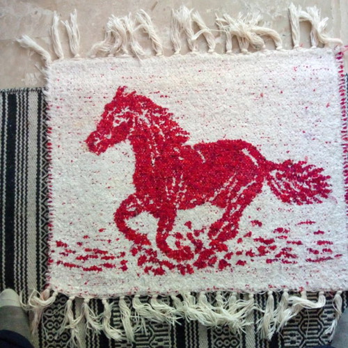 Red rug with white horse design like new, handmade