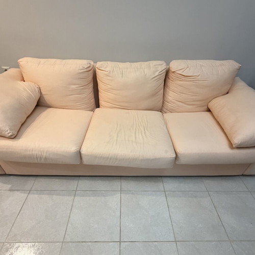Three-seater fabric sofa used, light pink-peach color with side cushions