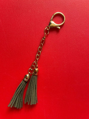 Keychain gold like new with green leather tassels