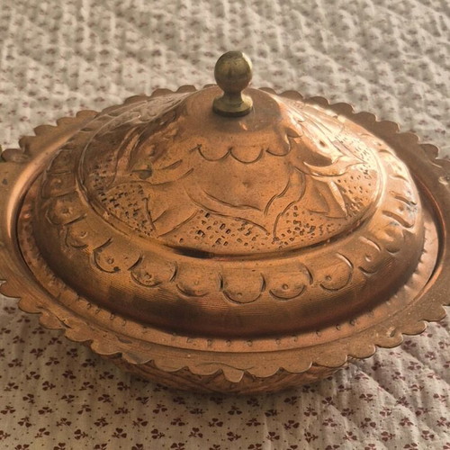 Traditional copper vessel with carved lid used