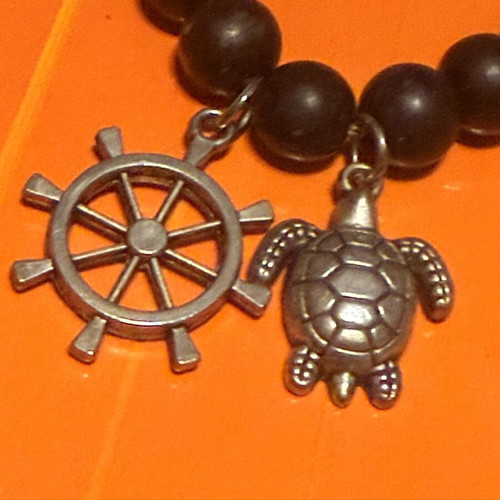 Elastic bracelet like new with steering wheel and turtle charms black-silver