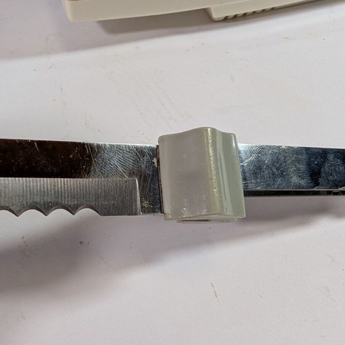 Electric kitchen knife used with 2 double serrated blades and wall mount