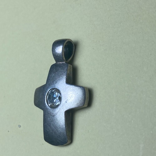 Silver cross used with stone