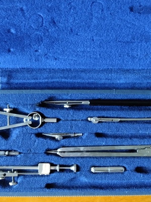 Drafting compass set used, missing one compass