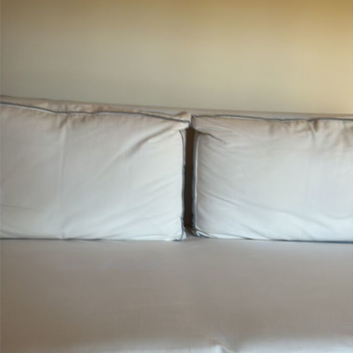 Two-seater sofa like new with ivory cover and grey-blue stitching