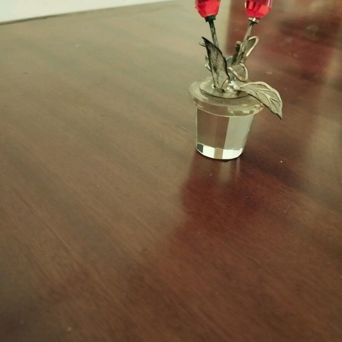 Glass bottle stopper used with decorative flowers and metal leaves
