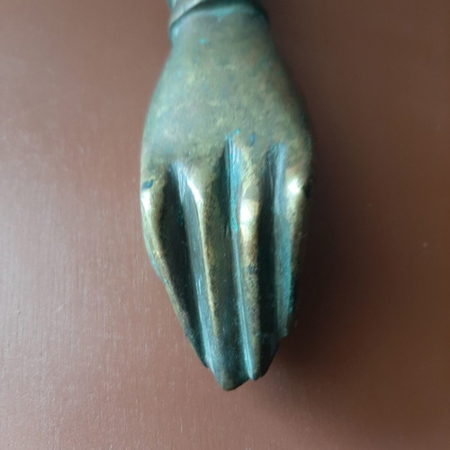 Antique bronze door knocker in hand shape