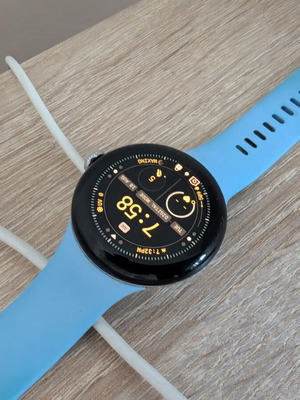 Google Pixel Watch 2 with charging base and extra metallic band