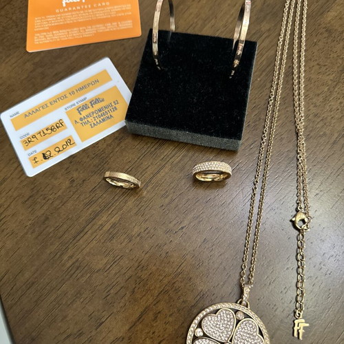 Folli Follie jewelry set with double-sided long necklace, hoop earrings, and two rings