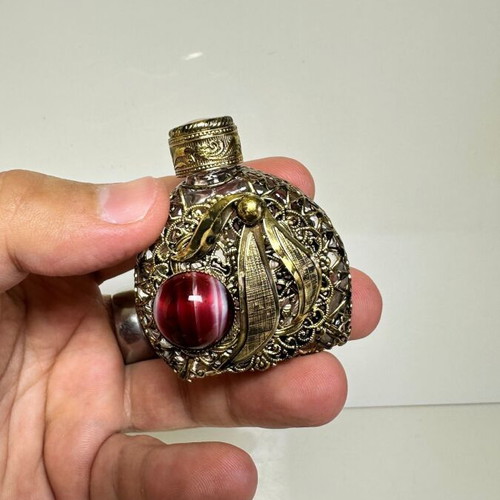 Vintage perfume flacon with filigree metalwork and red cabochon