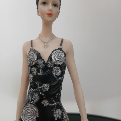 Decorative figurine of a girl with rose dress