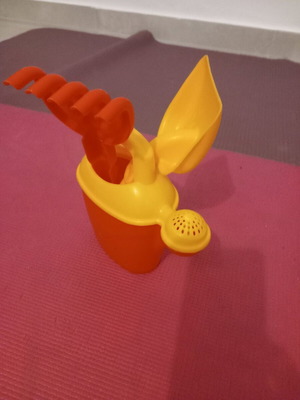 Children's beach watering can set used with shovel and rake