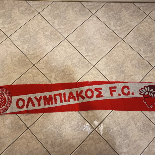 Real Madrid and Olympiakos accessories used with flag, scarf, and cap