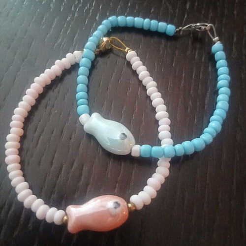 Two handmade island-style bracelets with beads and stone fish