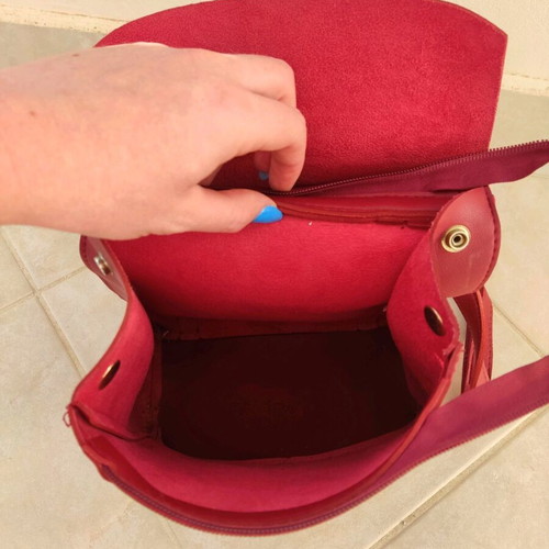 Red backpack used with broken zipper and mark
