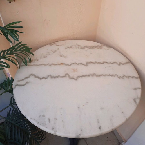 Round café-style table with marble top and cast iron base