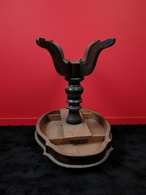 Round wooden table used with ornate base