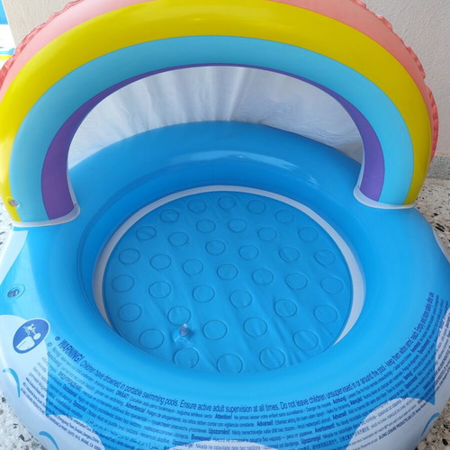 Blue children's pool with canopy used, rainbow design