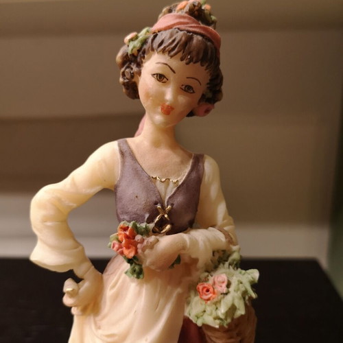 Porcelain figure used with wooden base and girl carrying flowers