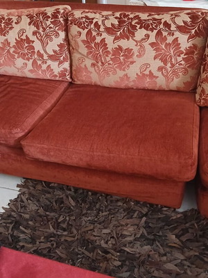 Corner sofa used with visible tears on back, functional