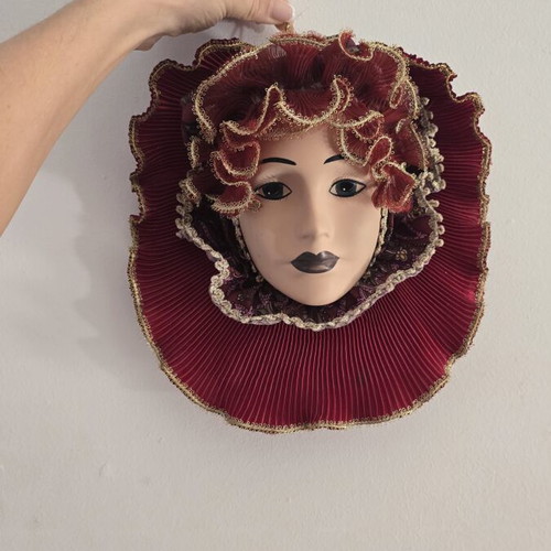 Decorative porcelain wall mask used with fabric hat in burgundy