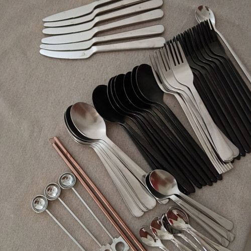 Various kitchen accessories with spoons, forks, knives, metal straws