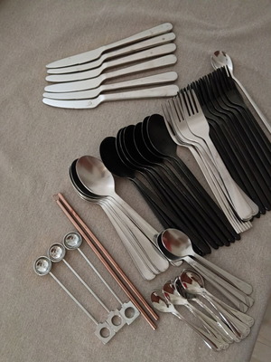 Various kitchen accessories with spoons, forks, knives, metal straws