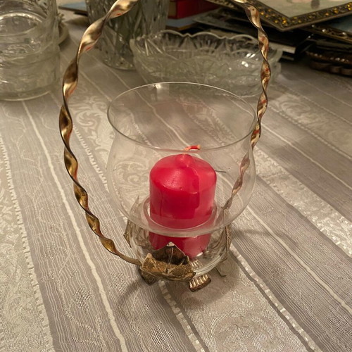 Metal candle holder with glass container used with candle