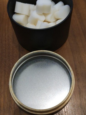 Wax melts in black matte metal container with choice of scent