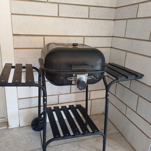 Charcoal grill used, wheeled with shelves and tools