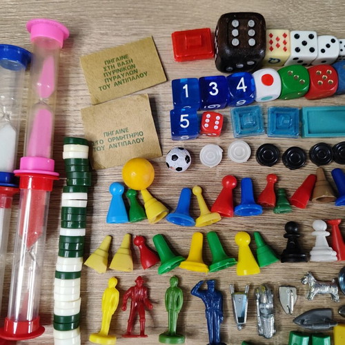 Lot of used board game parts including pawns, dice, cards, and hourglasses