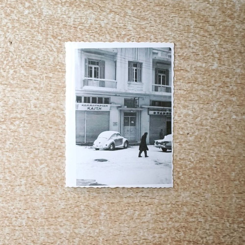 Vintage black and white photo Snowy street with VW Beetle and Kaiti hair salon