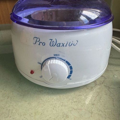 Pro-Wax 100 wax warmer used for hair removal with accessories