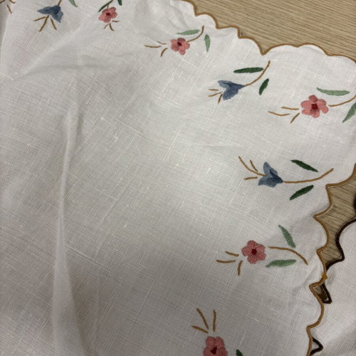 White embroidered table runner and napkin set used with colorful flowers