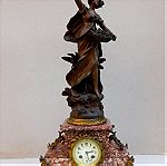  Ρολόι μεταλλικό με άγαλμα κοπέλας, μαρμάρινη βάση και δυο πεντάκερα κηροπήγια.