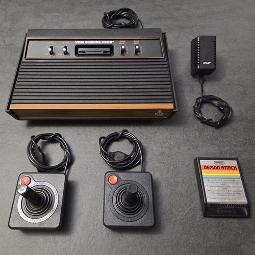 Atari 2600 VCS Woody console used with two joysticks and Demon Attack game