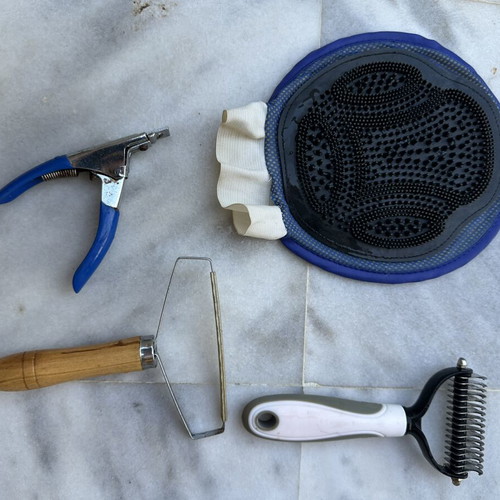 Pet grooming set with mat, glove brush, comb brushes and nail clipper
