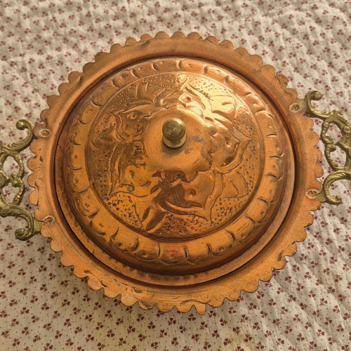 Traditional copper vessel with carved lid used