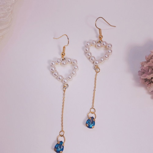Gold-tone dangling earrings with pearl heart and blue crystal